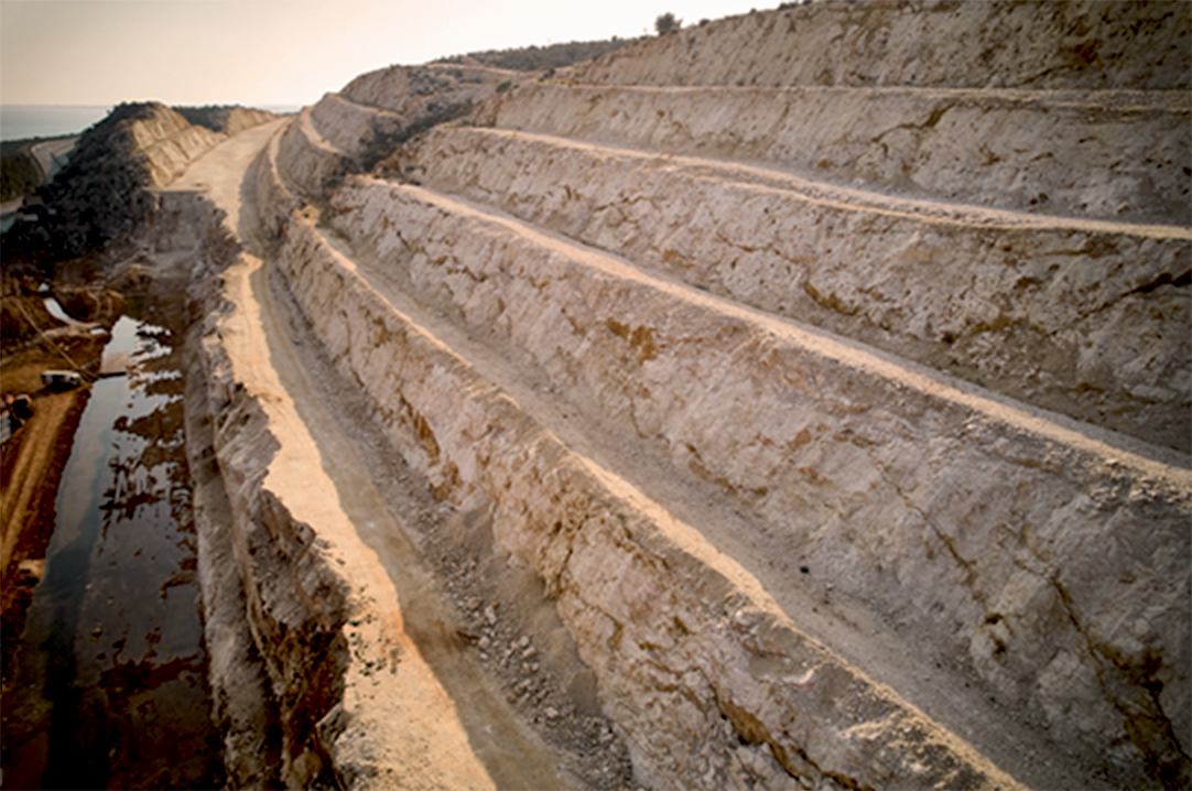 Geotechnical & Structural - Aerial view of highway ledges under construction after drilling and blasting operations. Road construction at rough highland terrain. Supports of bridge overpass under construction